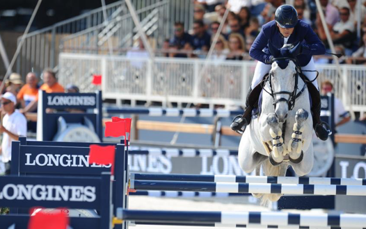 Laurent Guillet montant un cheval blanc durant une course d'obstacle